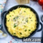 A bowl of polenta with mascarpone with tomatoes in the background.