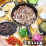 The Perfect Slow Cooker Pork Carnitas Spread 6 A platter of mexican food on a wooden table.