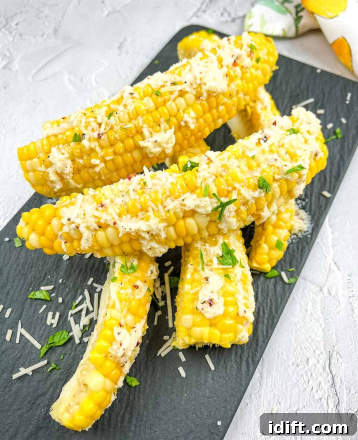 Crispy Parmesan-Garlic Corn Ribs garnished with fresh parsley on a sleek black plate.