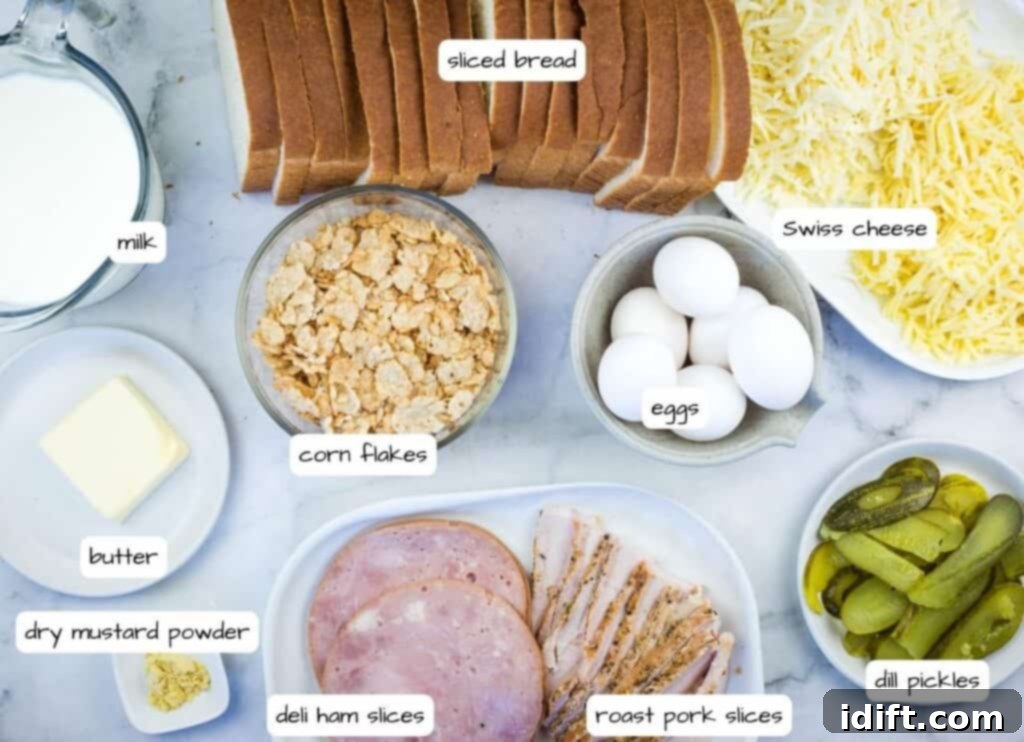 Cubano Casserole 5 A curated display of all ingredients for a breakfast sandwich, including bread, ham, eggs, milk, cheese, and pickles, meticulously arranged on a clean marble surface.