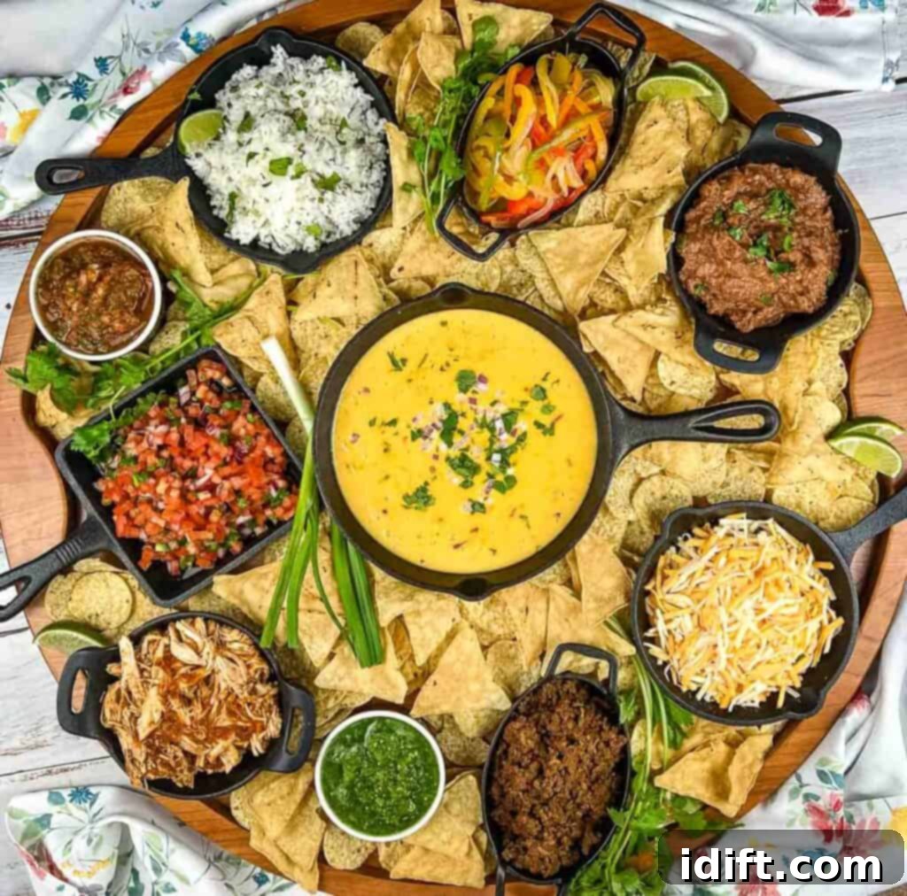 Mega Nacho Spread 2 A large platter of mexican food on a table, bursting with colorful nacho toppings like chips, meats, cheeses, and fresh vegetables.