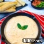 Pizza Fondue A Savory Spin on Classic Fondue 11 A skillet filled with Pizza fondue and bread on a red tablecloth. This delicious pizza fondue is a perfect party appetizer.