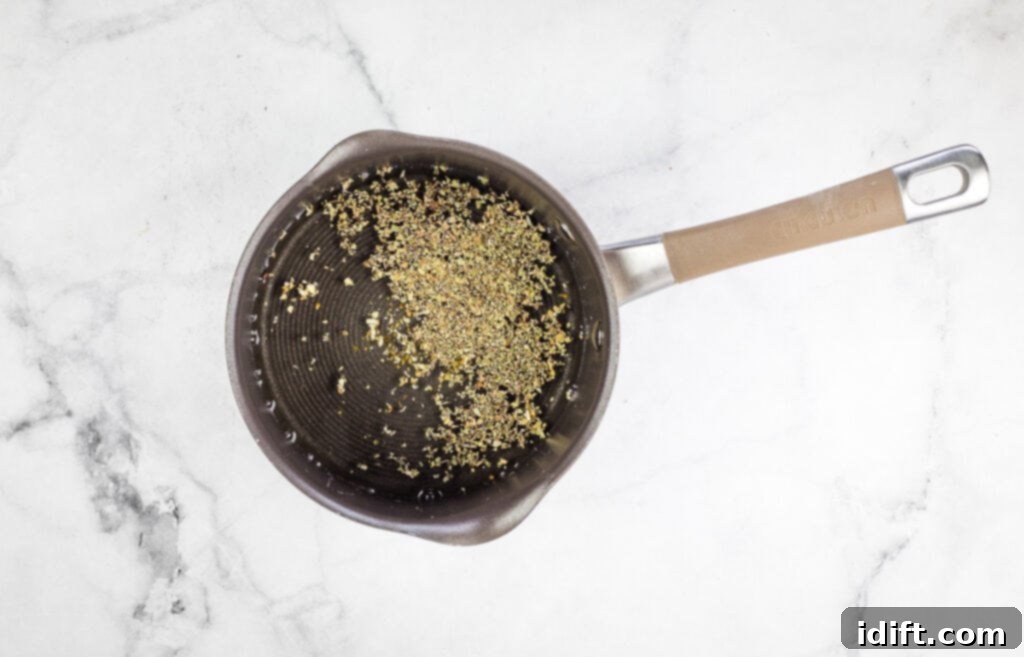 Pizza Fondue A Savory Spin on Classic Fondue 6 A pan with simmering white wine, garlic, and oregano on a marble surface, creating an aromatic base.