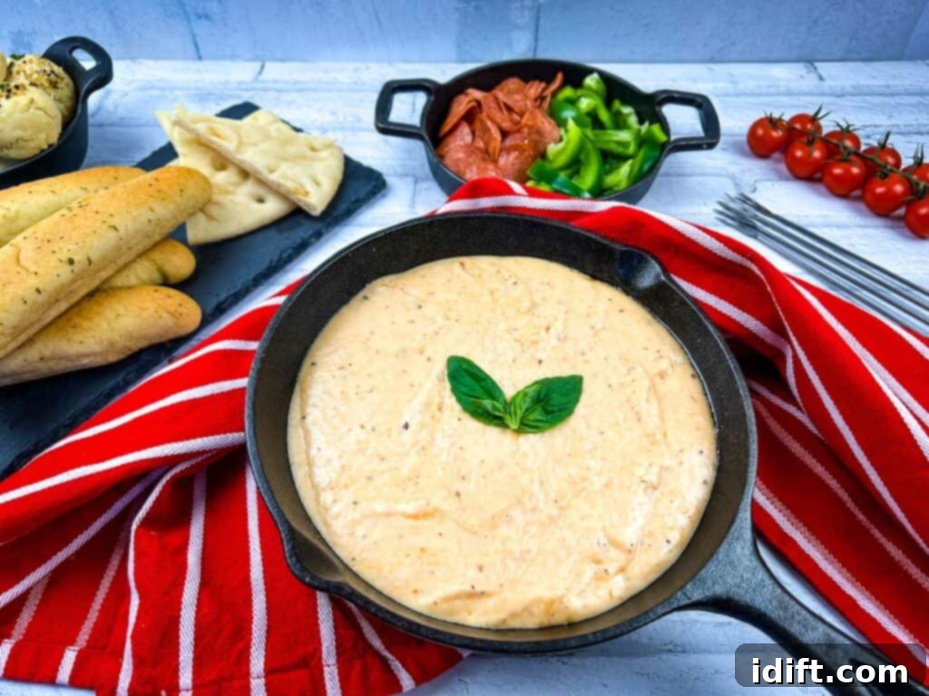 Pizza Fondue A Savory Spin on Classic Fondue 10 A bubbling cheesy dip in a skillet, garnished with fresh basil, surrounded by warm bread and cherry tomatoes on a dark surface.