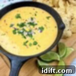 Mexican cheese dip in a cast iron skillet with tortilla chips.