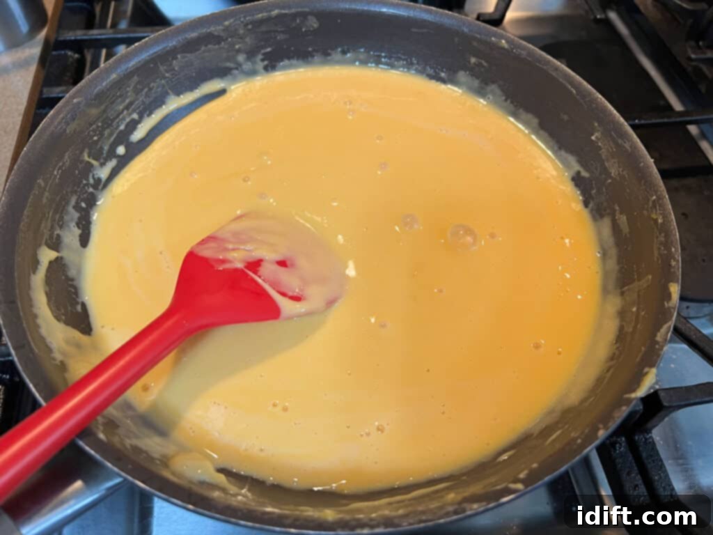 A frying pan with a red spatula.
