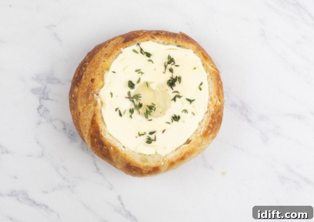 A pastry filled with butter and thyme on a marble surface.