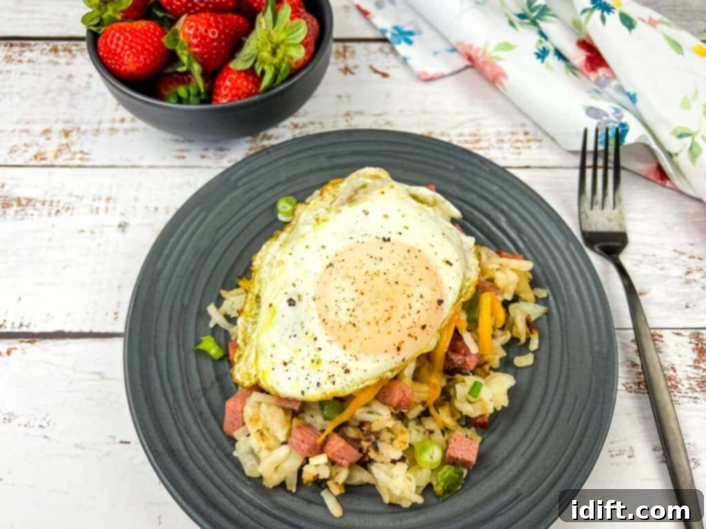 Classic Montreal Smoked Meat Hash 5 A plate of Montreal Smoked Meat Hash with a fried egg on top, garnished with fresh herbs.