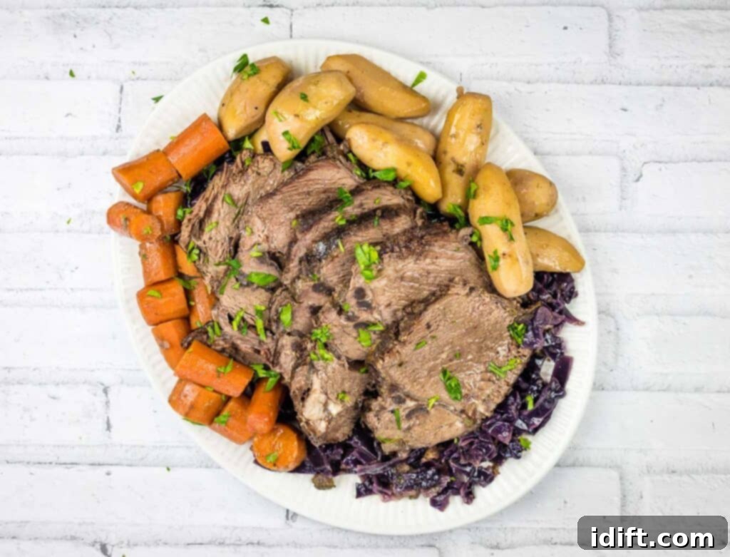 A beautiful top-down view of the finished German Pot Roast, served with sliced beef, red cabbage, and potatoes.
