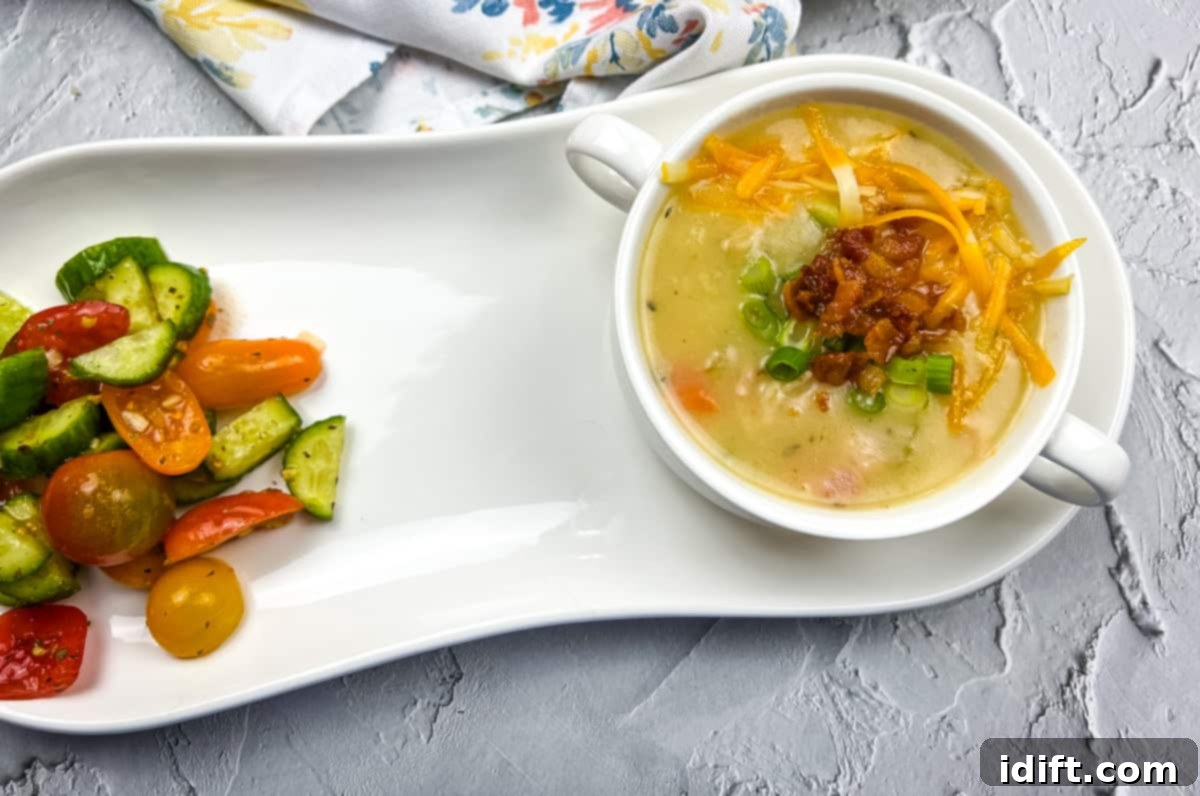 A white plate with fully loaded baked potato soup and vegetables on it.