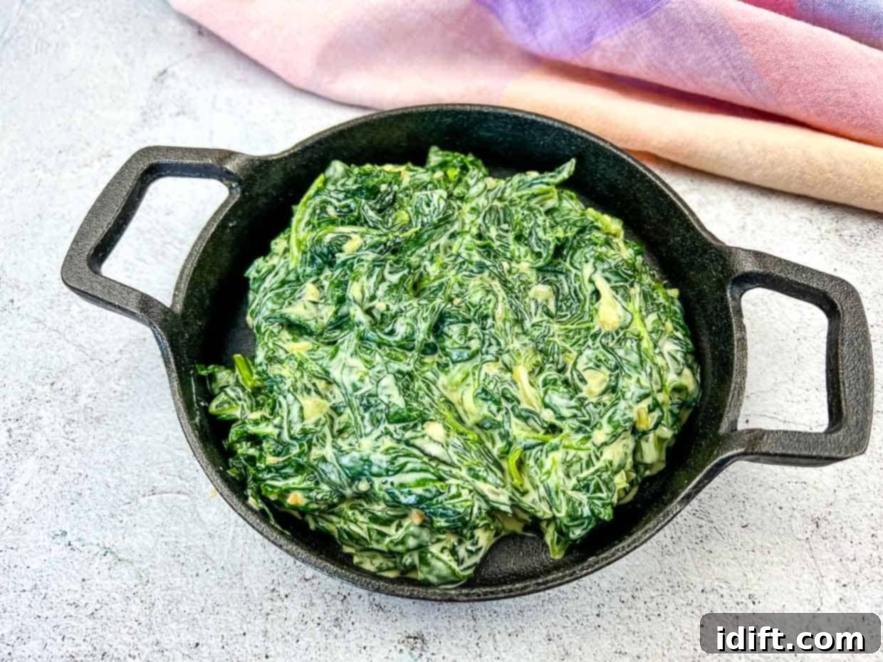 21 Italian Dishes Nonna Will Rave About 10 Creamed Spinach with Mascarpone in a black dish.