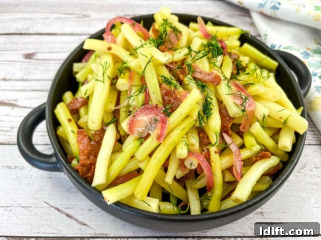 Timeless Tastes: 11 Vintage Recipes for the Modern Kitchen 6 A savory bowl of German Yellow Beans and bacon salad resting on a charming wooden table.