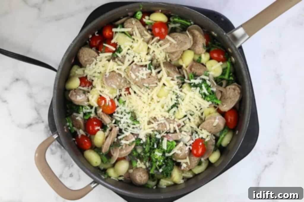 The finished Skillet Gnocchi with Sausage and Broccoli Rabe, generously topped with freshly grated Parmesan cheese, ready to be served.