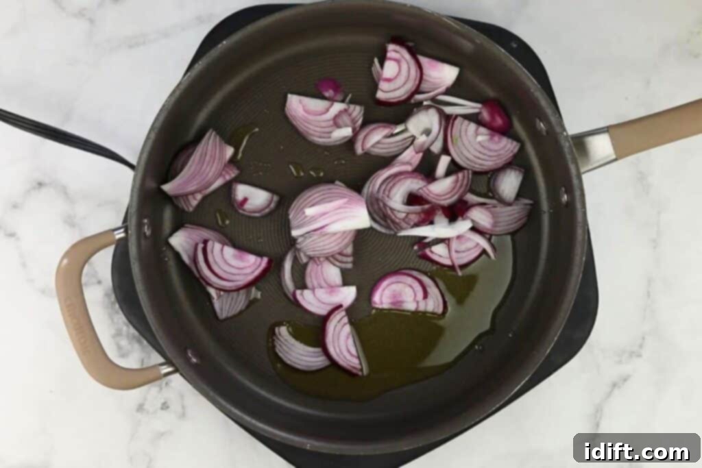 Sliced red onions and minced garlic gently sautéing in olive oil in a hot skillet.