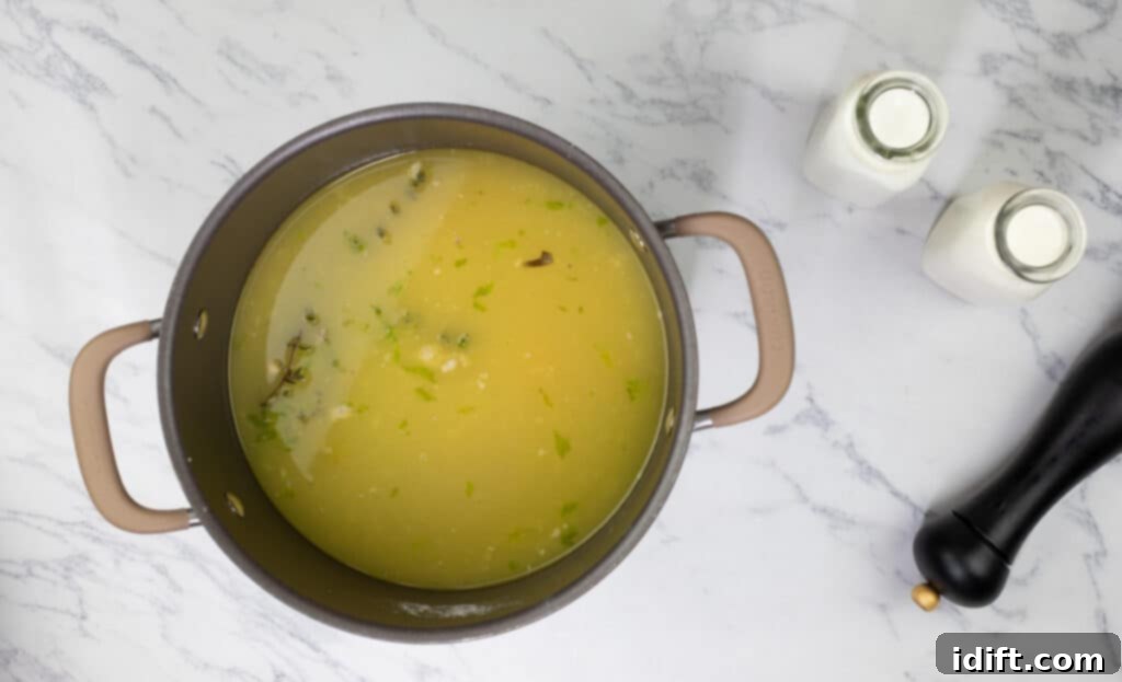 Rich Chicken and Wild Rice Soup 8 A pot of soup with wild rice and broth simmering on a stovetop.