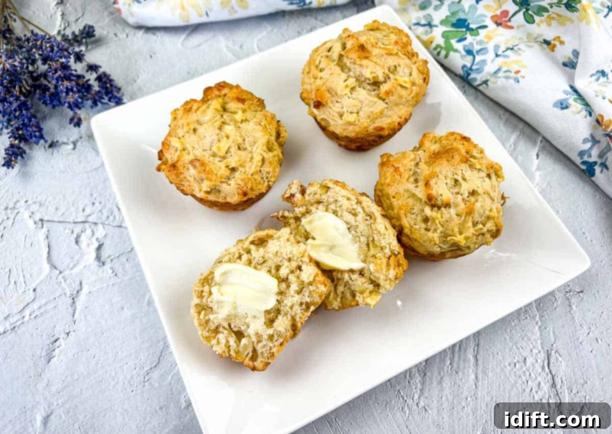 Apple Cheddar Muffins on a plate with one sliced open.