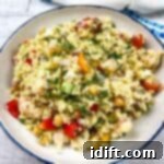 A plate of Mediterranean Orzo Salad with shrimp and vegetables.
