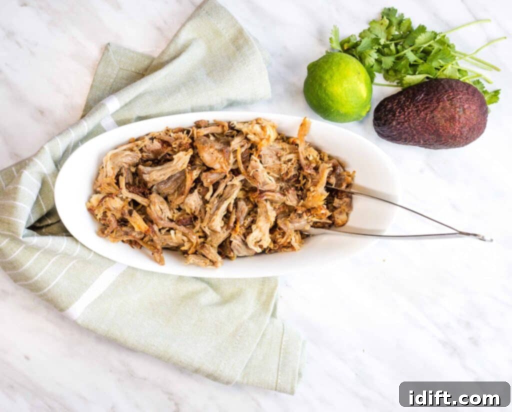 Platter of tender and flavorful Al Pastor Carnitas, garnished with fresh cilantro and lime wedges.