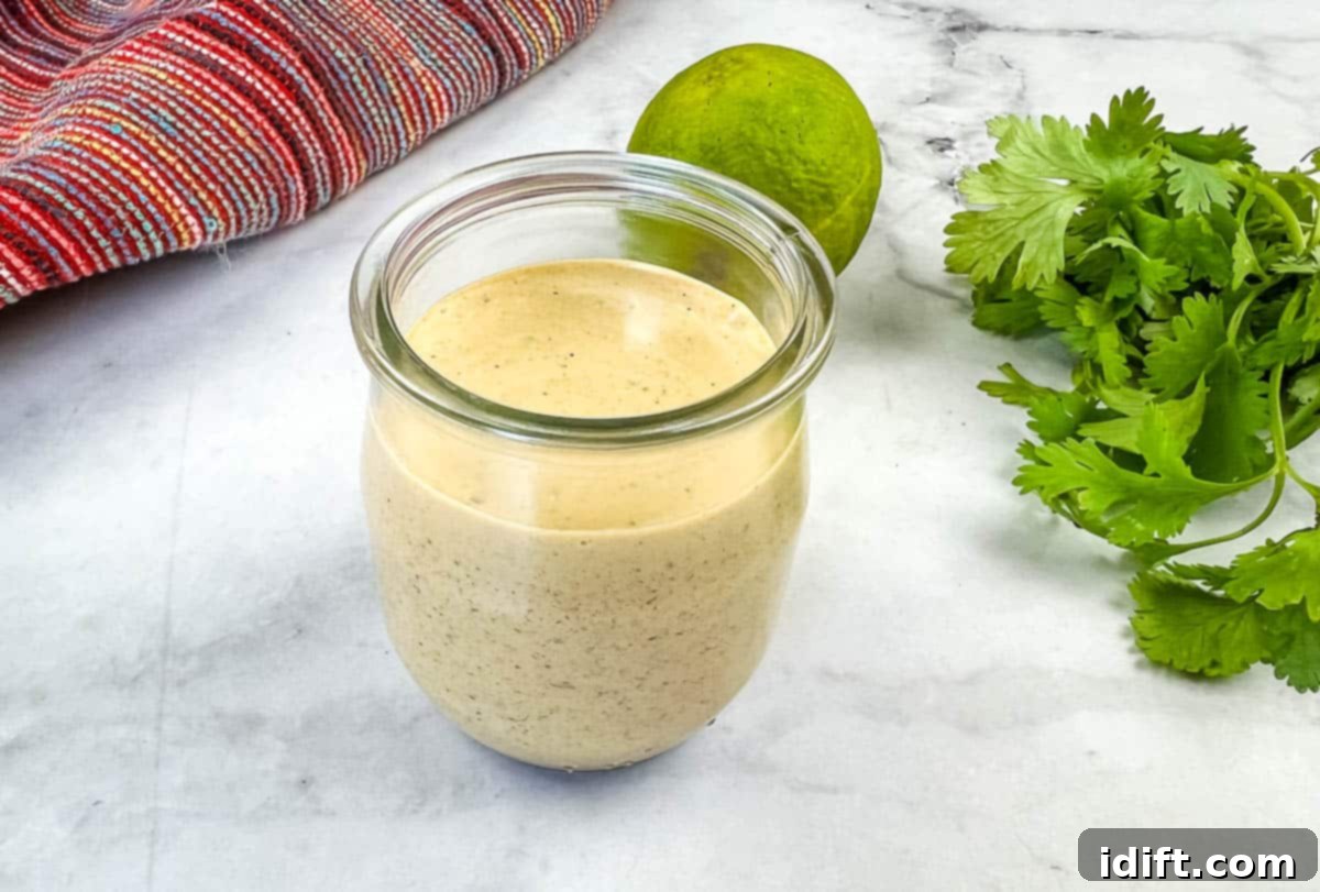 A jar of homemade Burrito Sauce with fresh lime and cilantro next to it.