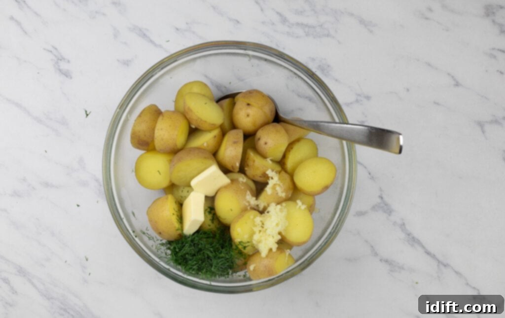Potatoes and dill in a bowl with a spoon.