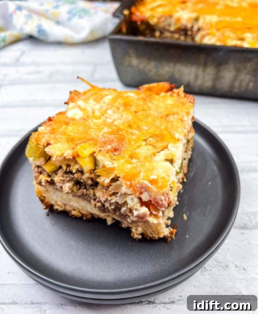 A square of John Wayne Casserole on a black plate, showcasing its cheesy, meaty layers.