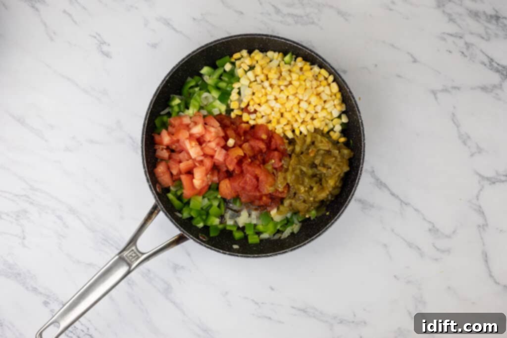 A colorful mix of corn, tomatoes, and other vegetables heating in a frying pan.