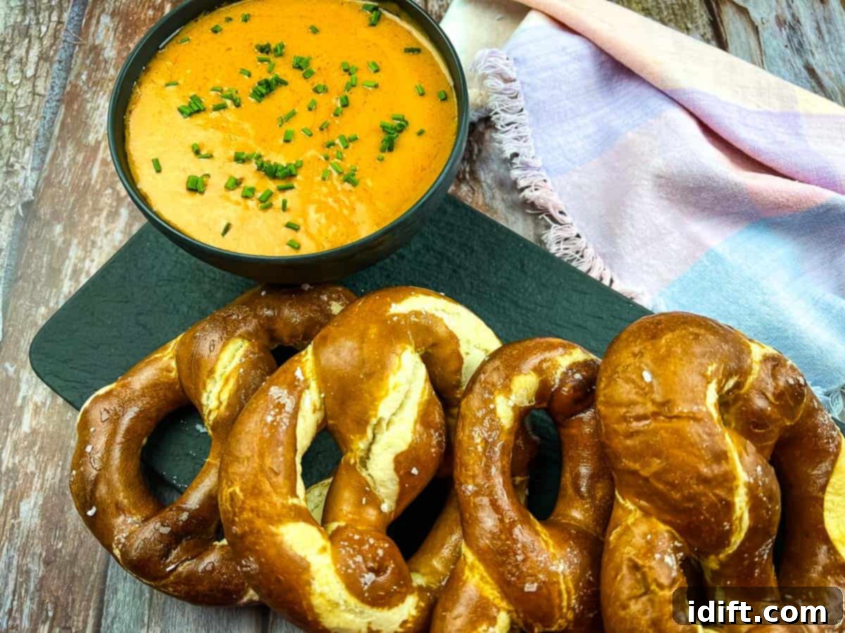 Guinness Cheese Dip on a platter with soft pretzels.