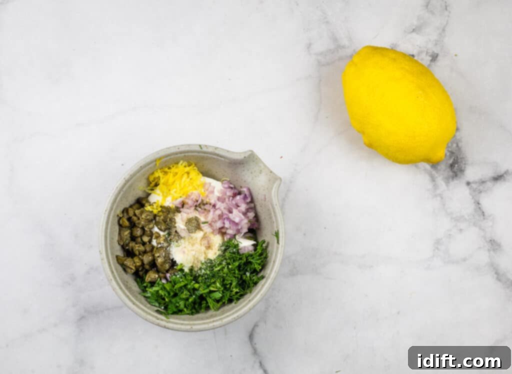 A bowl of ingredients next to a lemon on a marble table.