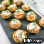 Smoked salmon tartlets with dill on a tray.