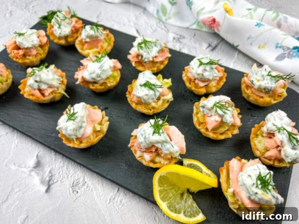 Salmon tartlets with sour cream and lemon wedges.