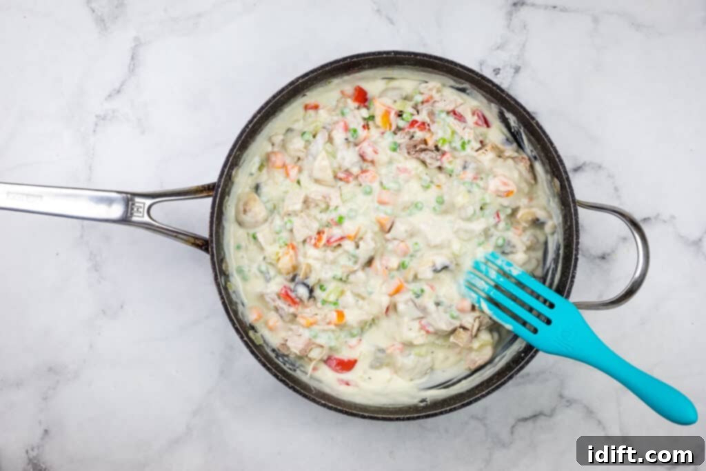 A frying pan with a blue fork in it.