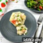 A black plate with a turkey a la king on it with a salad.