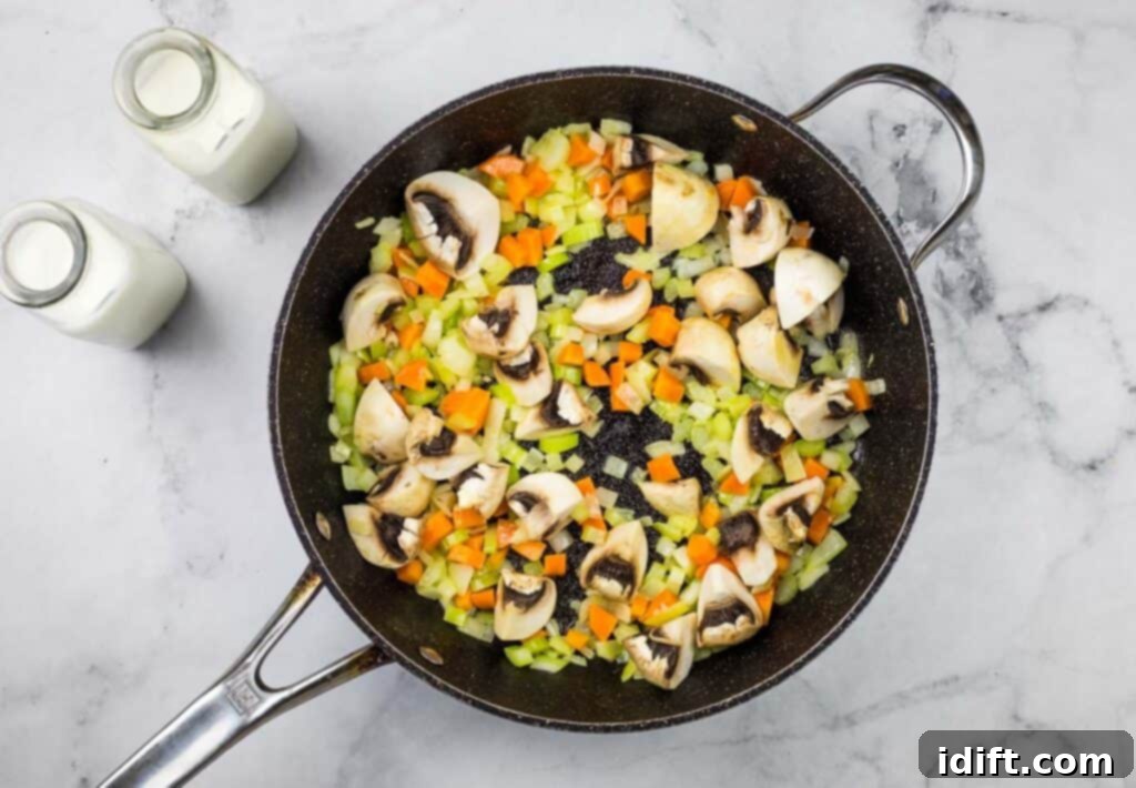 A frying pan full of vegetables and mushrooms.