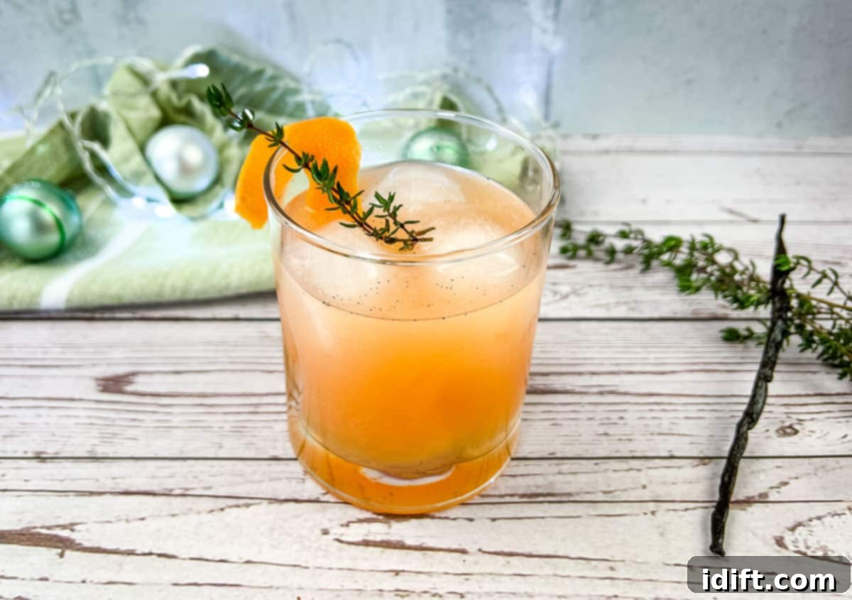 25 Recipes That Will Steal Your Heart 3 A refreshing winter vanilla thyme paloma mocktail, garnished with a sprig of fresh thyme, in a clear glass.