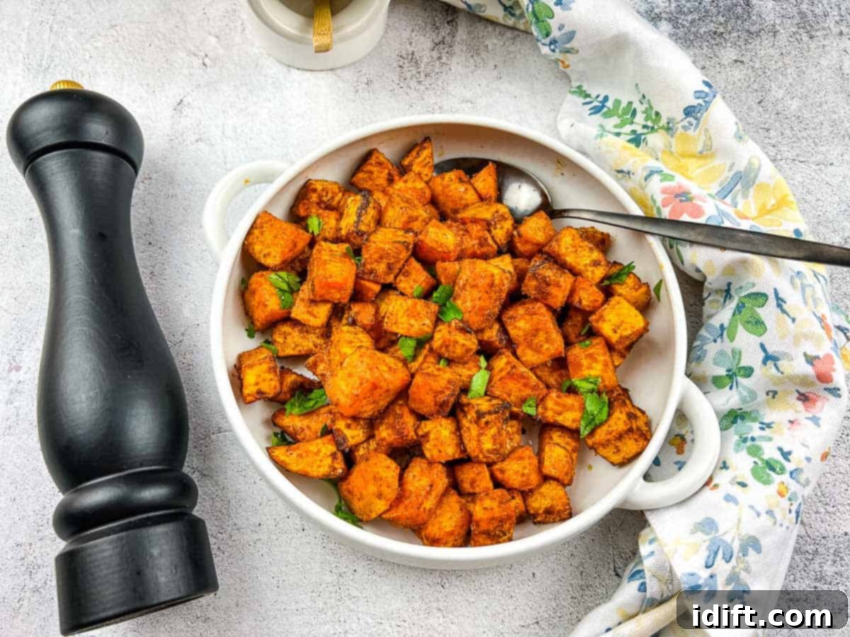 A closeup of Air Fryer Sweet Potato Cubes in a white serving dish, perfectly golden and seasoned.