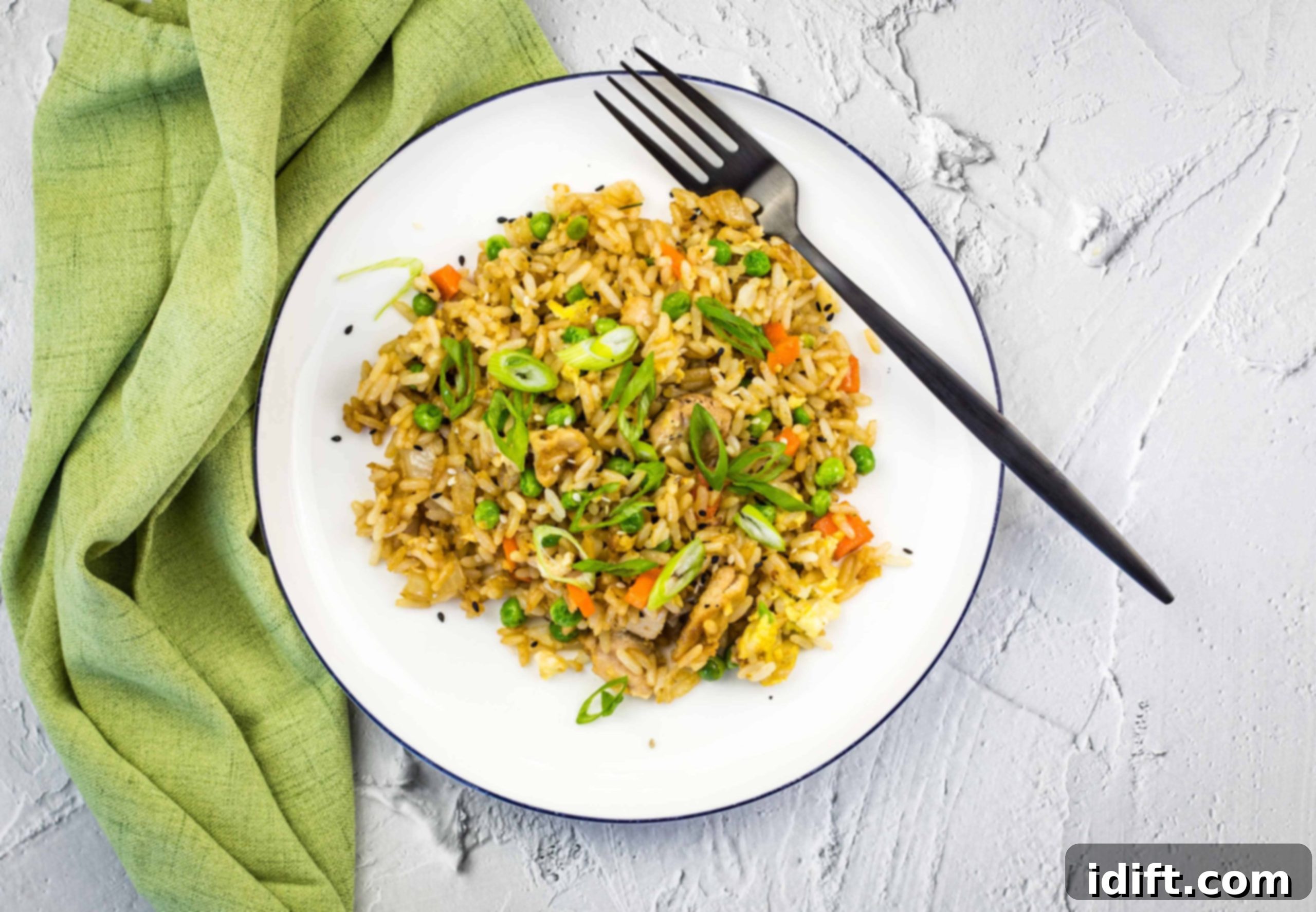 17 Heartwarming Comfort Foods Straight From Grandmas Kitchen 3 Chicken fried rice on a white plate with a green napkin.