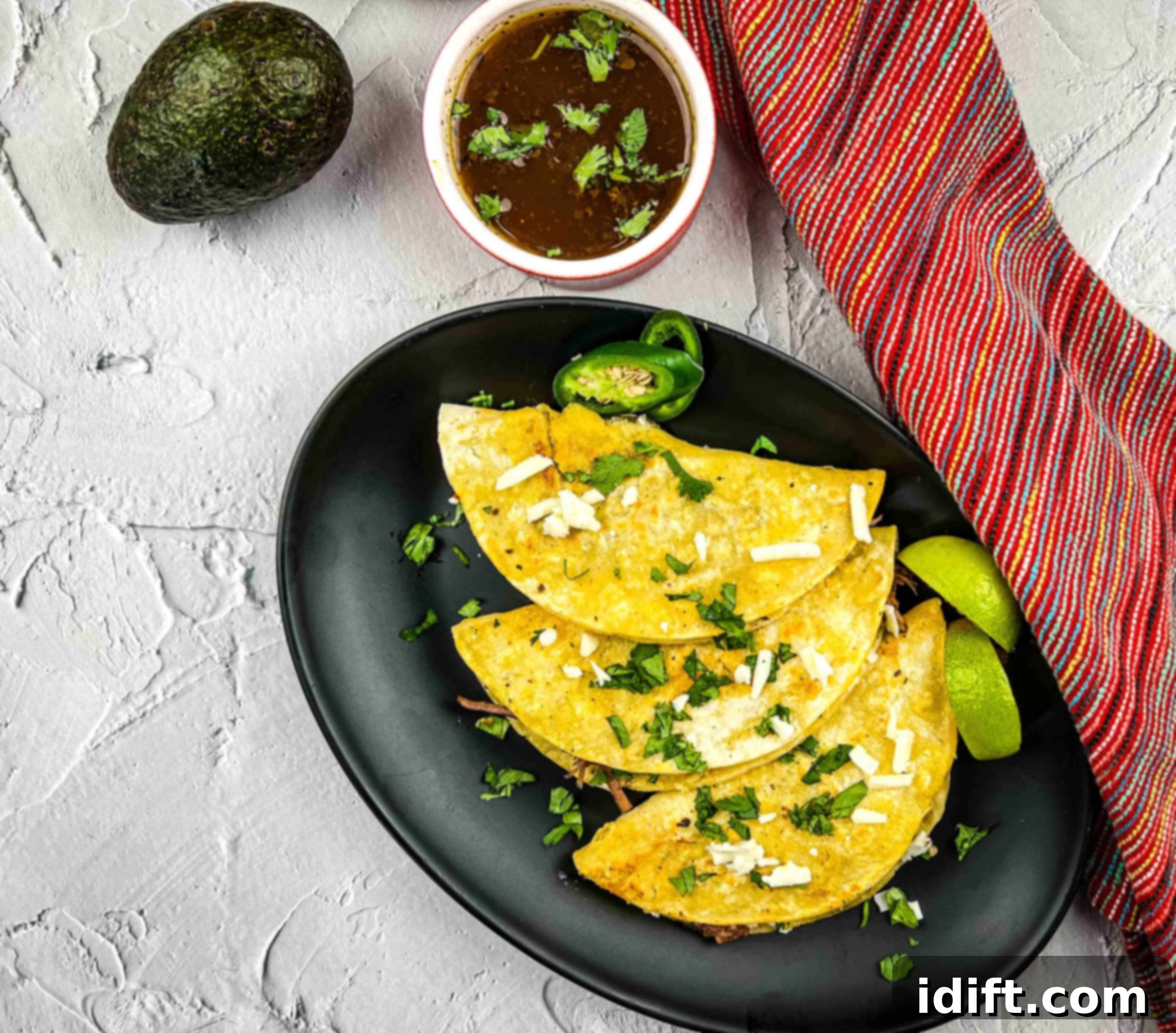 17 Heartwarming Comfort Foods Straight From Grandmas Kitchen 8 Birria Tacos on a plate with consomme.