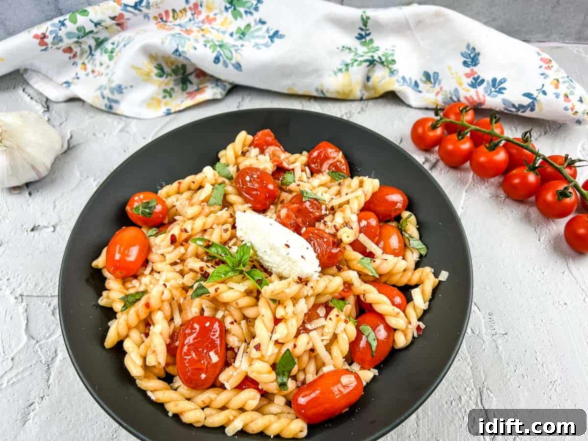 11 Mediterranean Dishes Your Passport to Flavor 7 A vibrant bowl of pasta generously topped with fresh cherry tomato sauce, whole cherry tomatoes, and aromatic garlic cloves, showcasing rustic Italian simplicity.