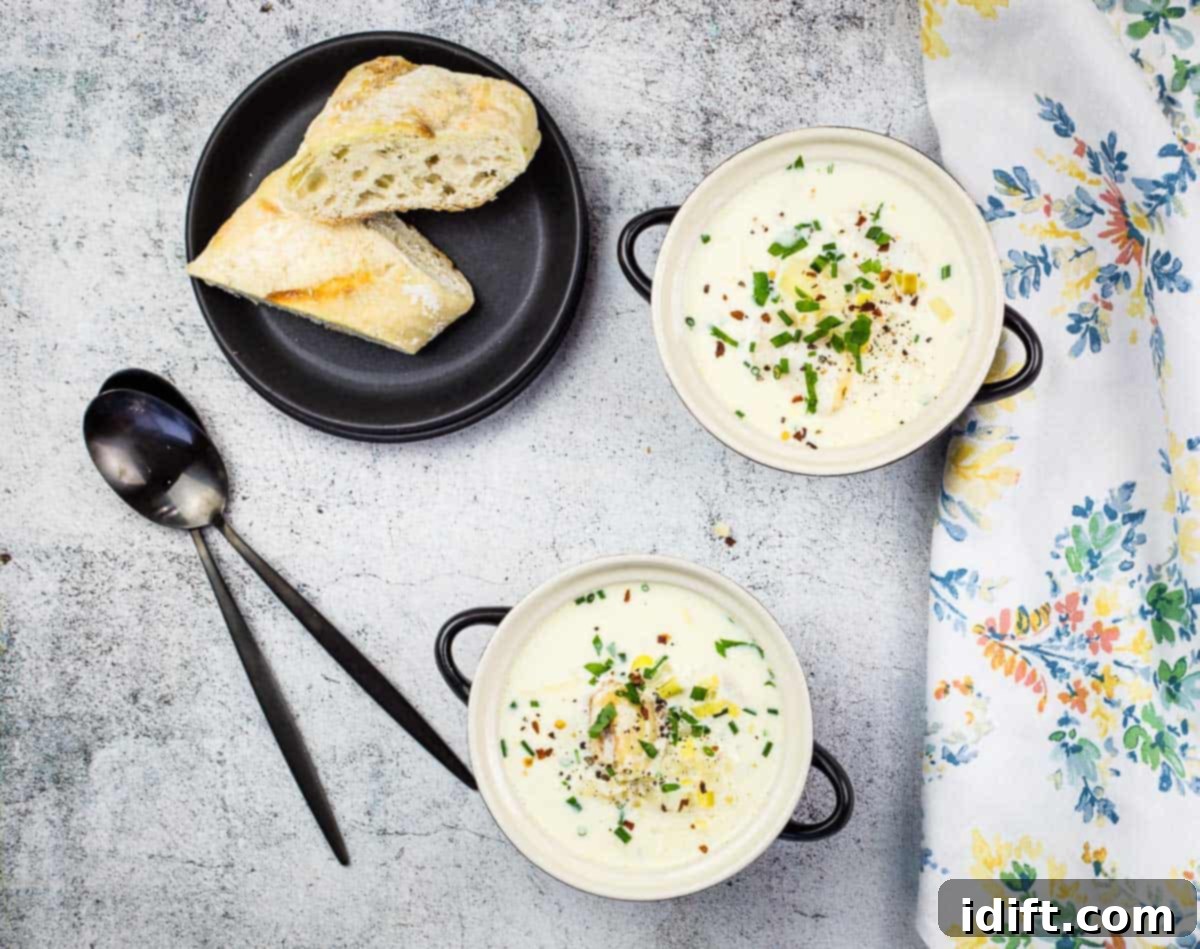 Two bowls of traditional Cullen Skink, a creamy Scottish smoked haddock soup, with crusty bread in the background.