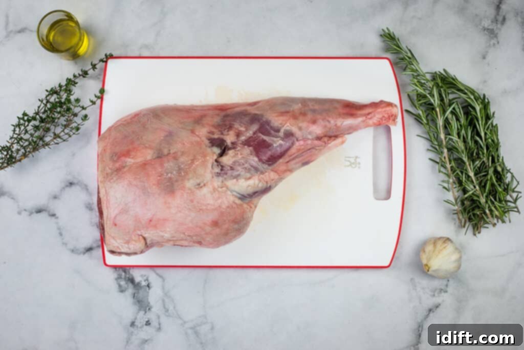 All the fresh ingredients—lamb, rosemary, thyme, garlic, and olive oil—arranged on a cutting board, ready for preparation.