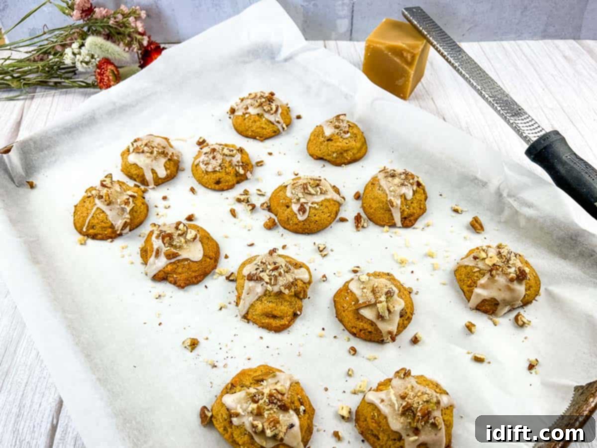 Sweet Potato Cookies on a baking sheet with icing and nuts.