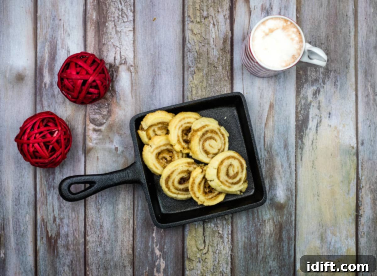 Cinnamon roll cookies in a skillet on a wooden table.