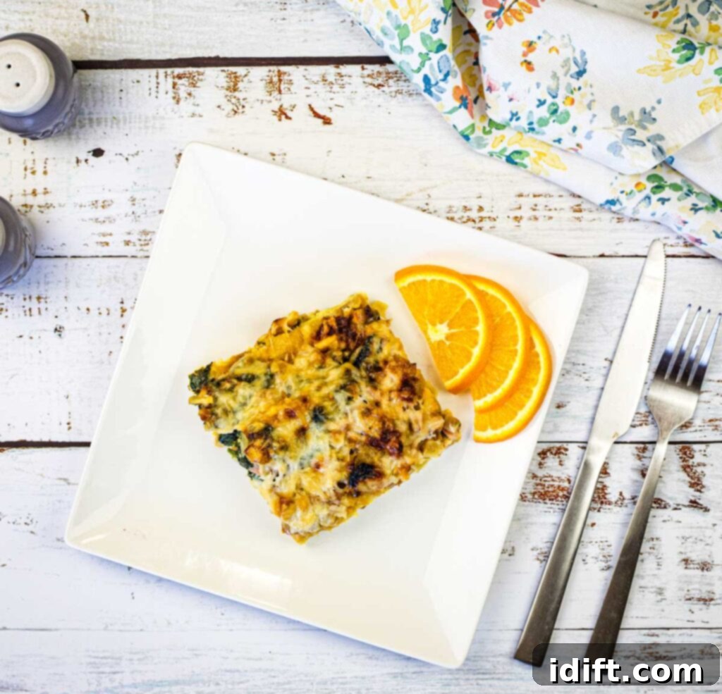 Fluffy Croissant Breakfast Delight 11 A plate of Croissant Breakfast Casserole with a slice of orange on it.