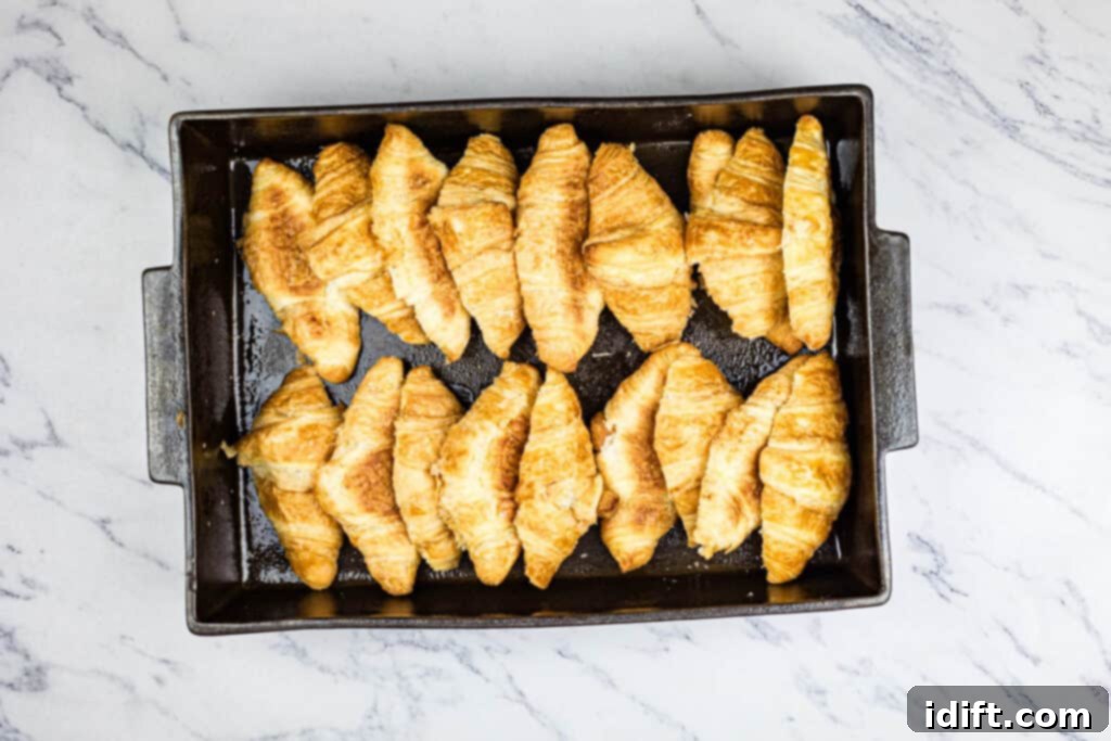 Fluffy Croissant Breakfast Delight 6 Croissants in a baking pan on a marble countertop.