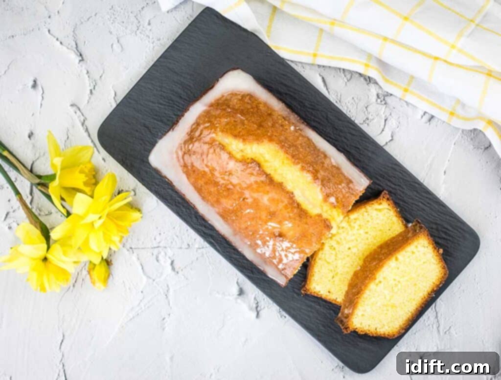 A top-down shot of sliced lemon loaf on a black platter.