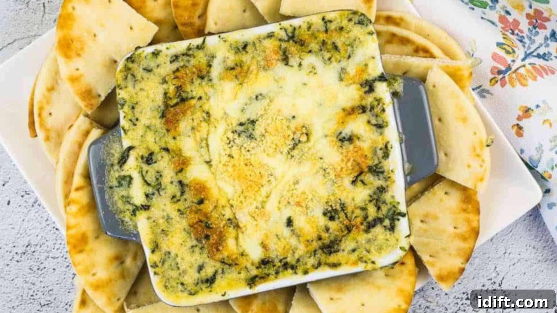 Elevate Your Event 11 Appetizer Masterpieces 5 A warm, bubbling Spinach & Brie Dip in a rustic casserole dish, generously surrounded by an array of toasted pita wedges, inviting guests to scoop up the creamy, cheesy goodness.