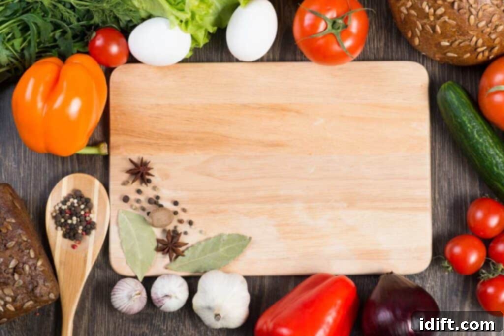 A wooden cutting board surrounded by vegetables and herbs.