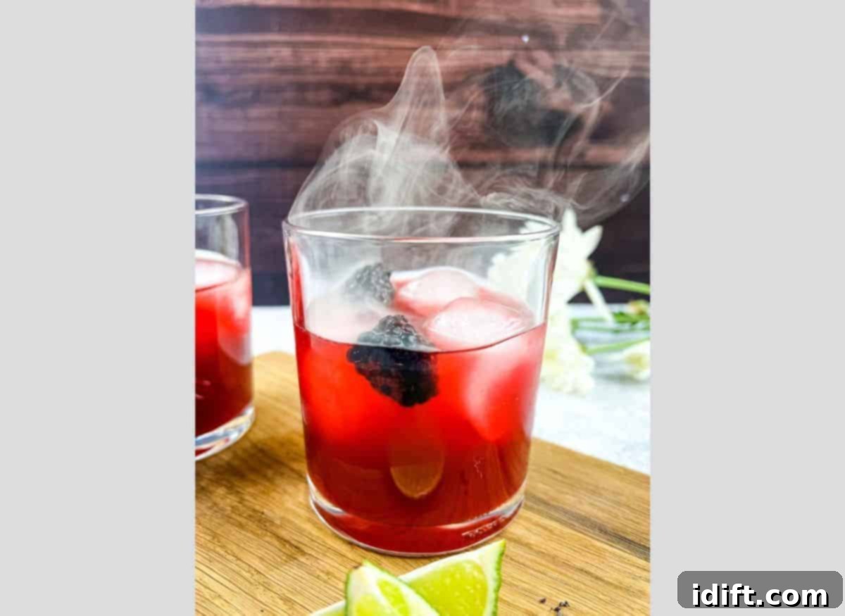 Smoked Blackberry Margarita with smoke coming out the top of the glass.