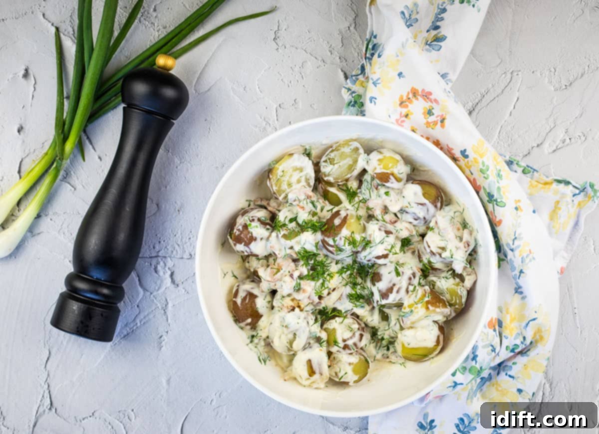 A generously filled bowl of creamy, tender potatoes lavishly topped with crispy, savory bacon bits and a dollop of cool, tangy sour cream, ready to serve as the ultimate comfort side dish.