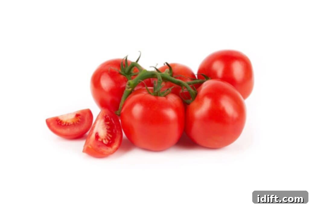Tomato Bounty: Your Comprehensive Guide to Varieties and Tastes 4 A close-up shot of a cluster of ripe red tomatoes on the vine, with one tomato expertly sliced to reveal its juicy interior, against a clean white background, emphasizing freshness and quality.